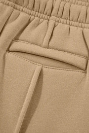 Close-up of a side pocket on tan wide-leg pants.