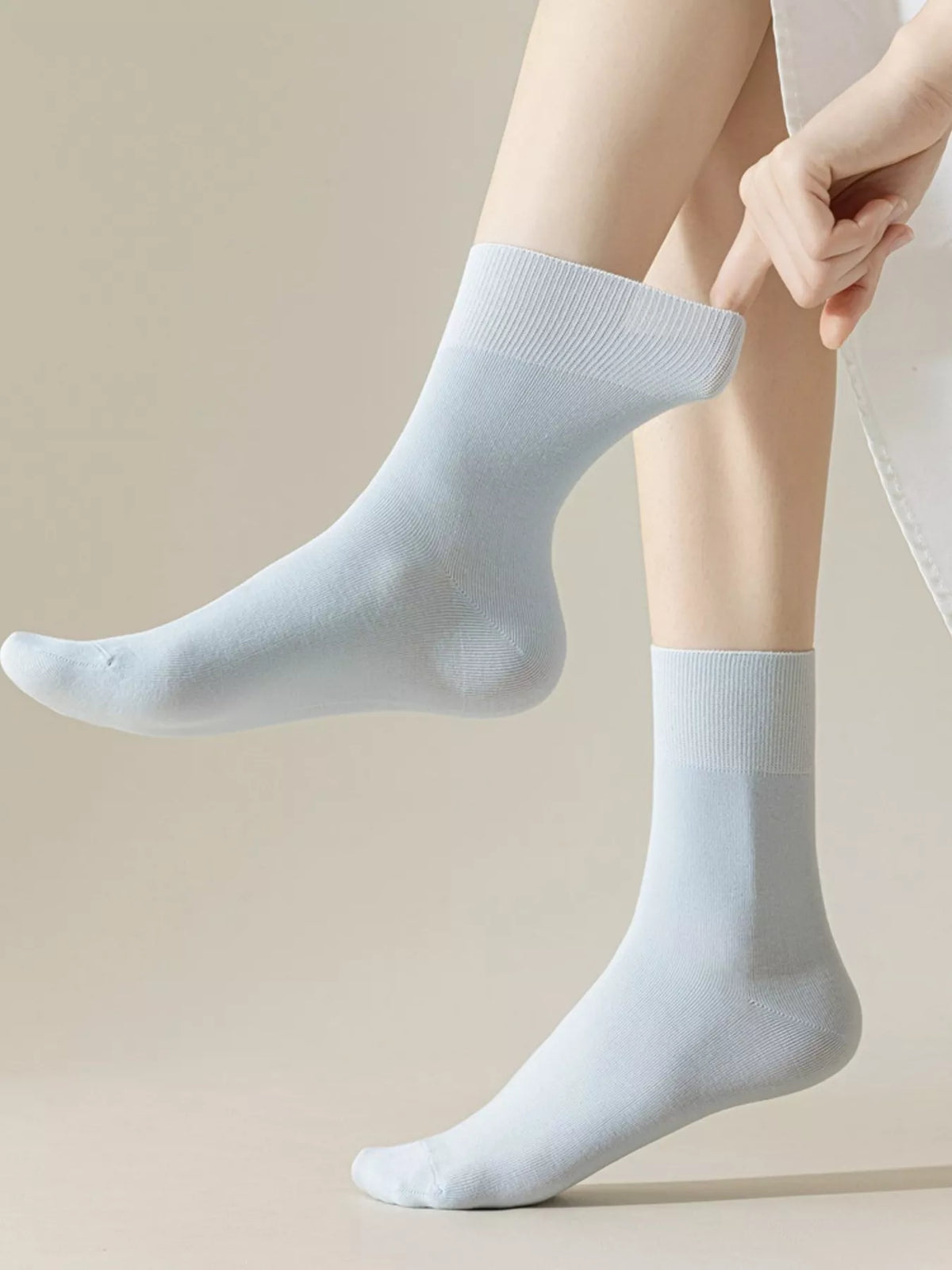 Light blue crew socks worn on feet, showing ribbed cuffs
