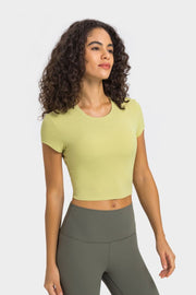 Model in pale yellow cropped T-shirt and gray leggings, three-quarter view