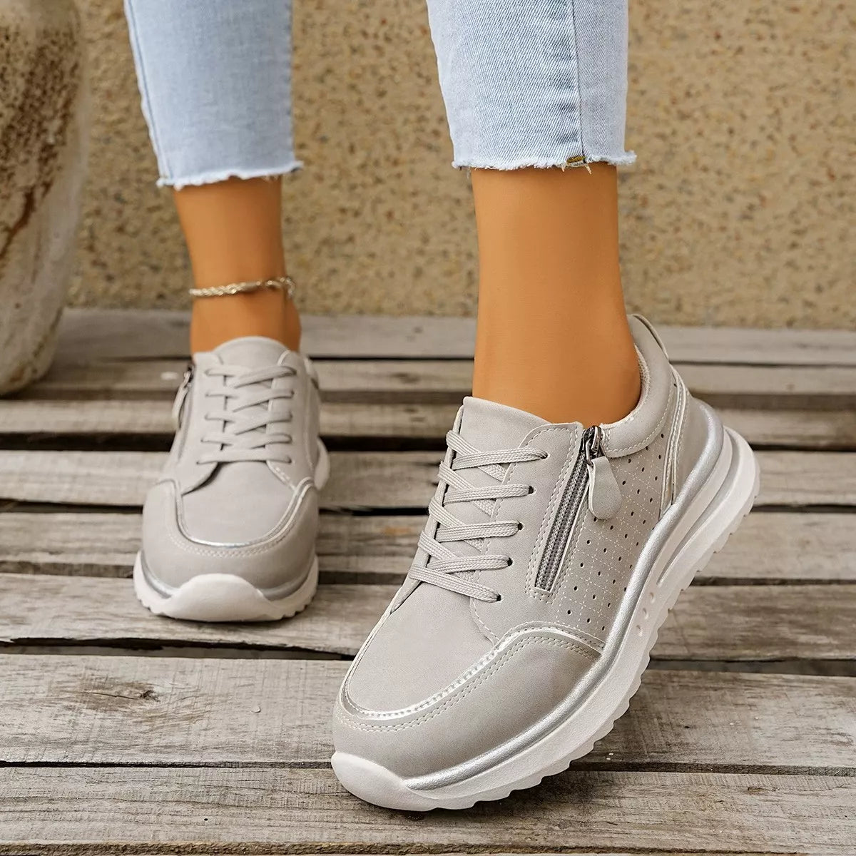 White lace-up sneakers worn with jeans, front view