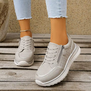 White lace-up sneakers worn with jeans, front view