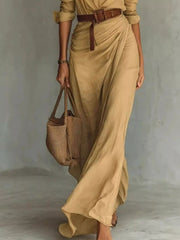 Close view of the camel dress's button-front waist, belt and draped skirt.