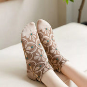 Brown floral ankle socks with beige toes shown on raised feet
