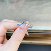 Close view of the V-shaped band with clear stones held between fingers.