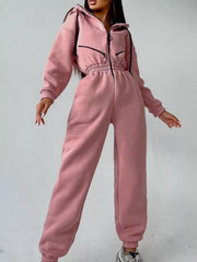 Women's rose pink hooded jumpsuit, model front view with arms lowered