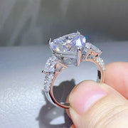 Side view showing the raised clear heart stone and silver setting.