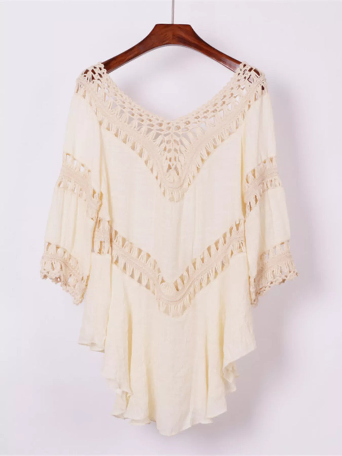 Black cover-up dress with crochet trim displayed on a hanger