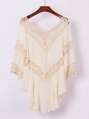 Black cover-up dress with crochet trim displayed on a hanger