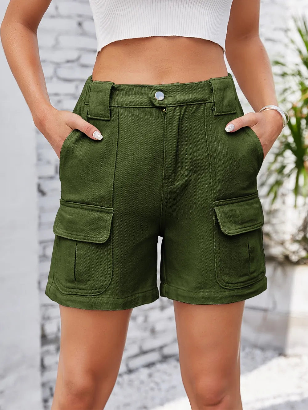 Front view of olive green cargo shorts with flap pockets.