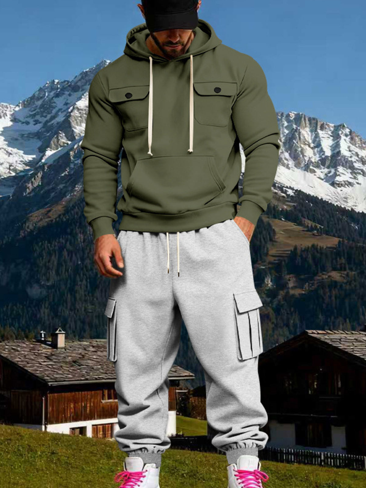 Front view of a model wearing an olive hoodie with chest flap pockets and grey cargo sweatpants