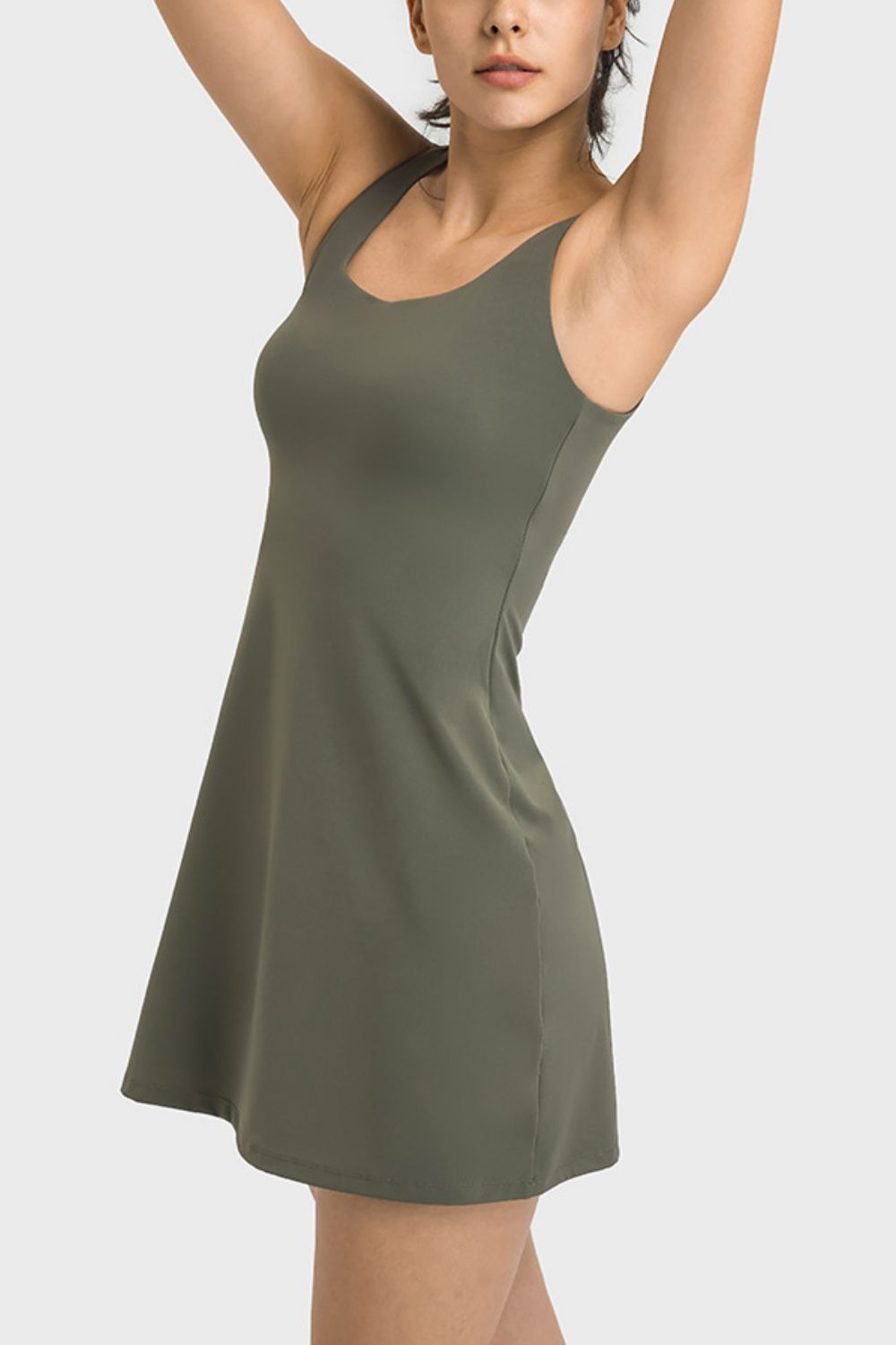 Angled view showing the fitted bodice and flared skirt of the olive tank dress.