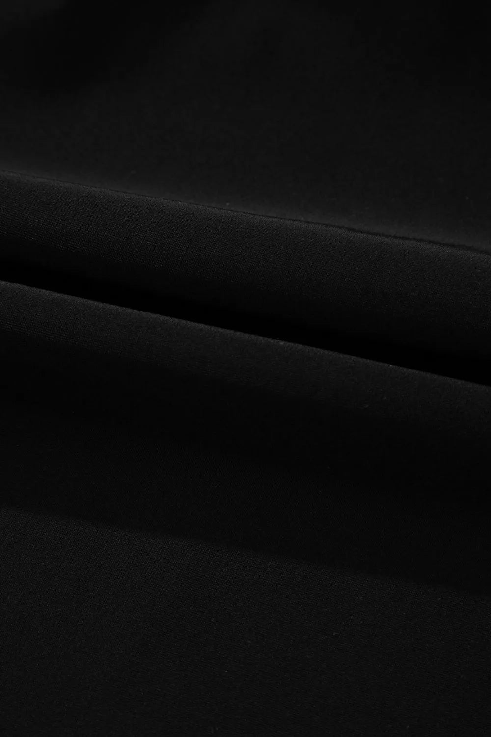 Detail of the black swim dress skirt fabric and seam.