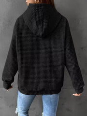 Back view of black textured hoodie with hood