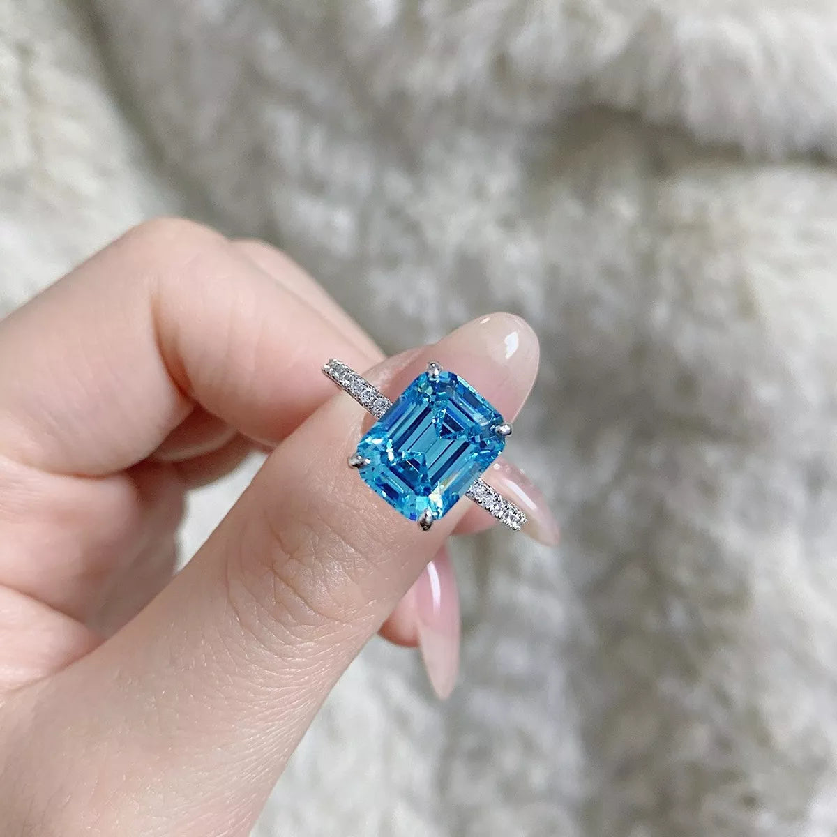 Three-quarter view of a silver cushion-halo ring with pavé shoulders.