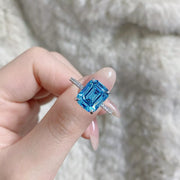 Three-quarter view of a silver cushion-halo ring with pavé shoulders.