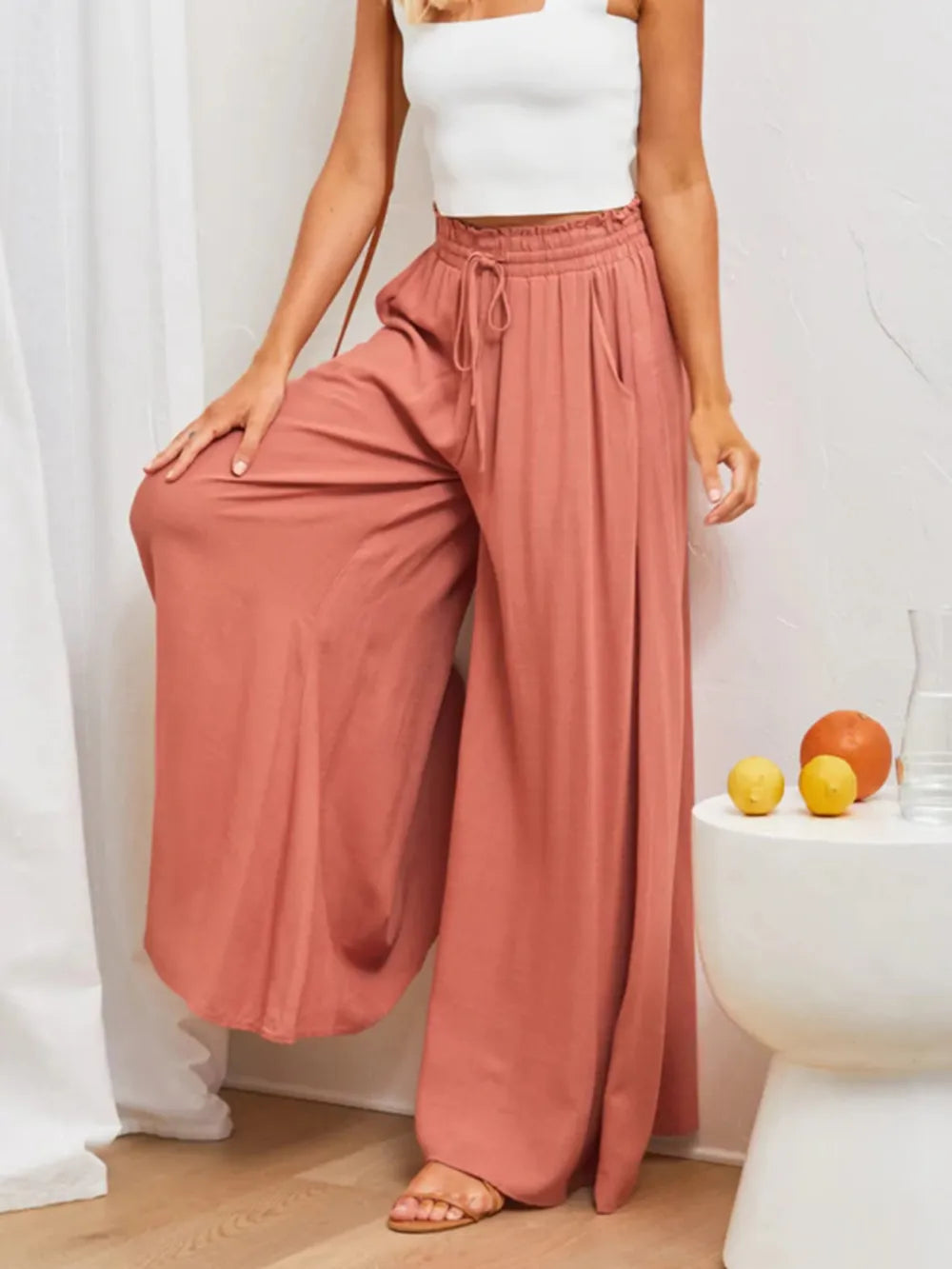 Model wearing rose-colored high-waist wide-leg pants, front view