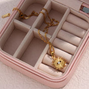 Gold-tone evil eye pendant necklace arranged in a jewelry case