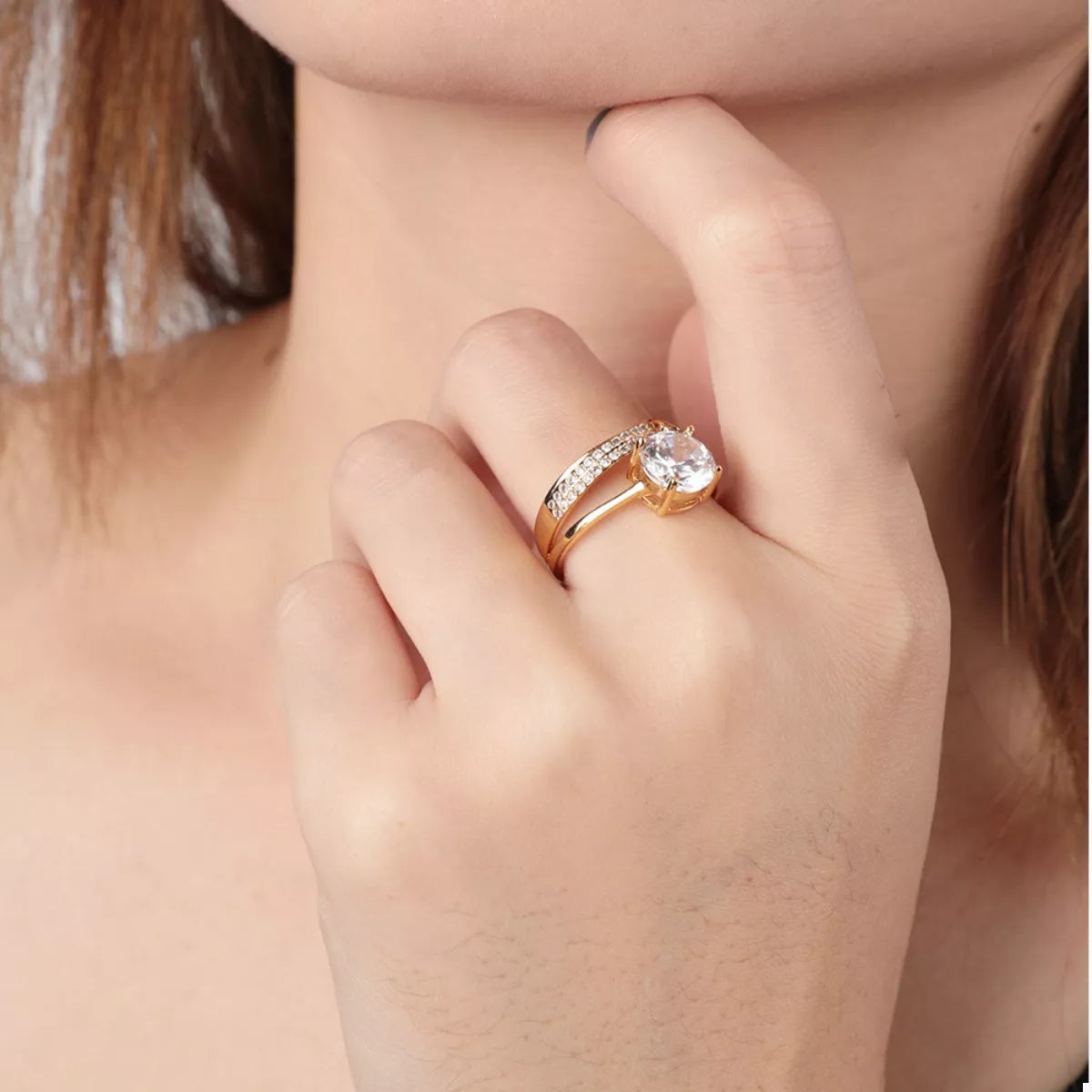 Gold-tone ring with a clear center stone and rectangular clear side stones
