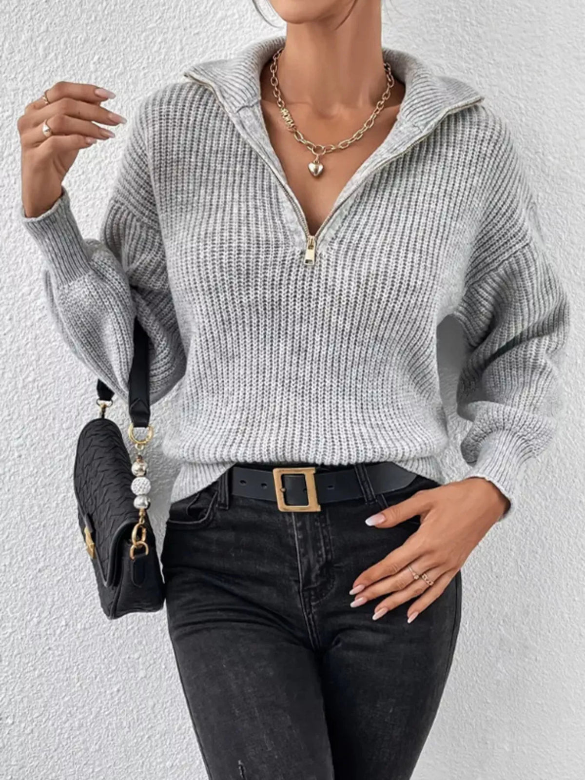 Model wearing light grey ribbed quarter-zip sweater with a black shoulder bag