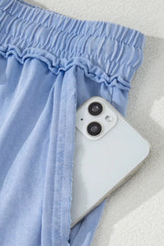 Close-up of side pocket on light-blue shorts with phone tucked inside