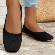 Black square-toe mesh flats worn, showing the patterned toe panels