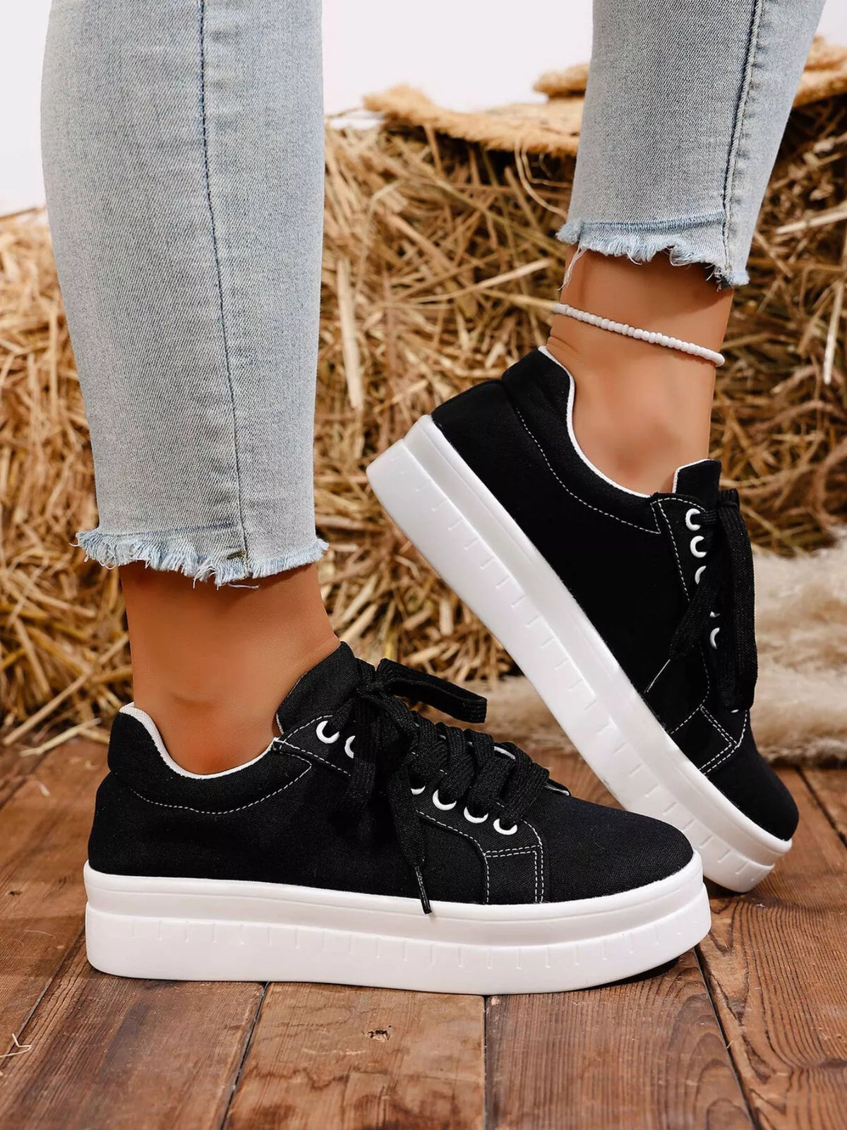 Black platform sneaker worn with jeans, side view