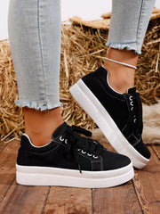 Black platform sneaker worn with jeans, side view