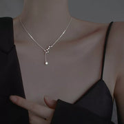 Close view of silver star necklace worn over a black top