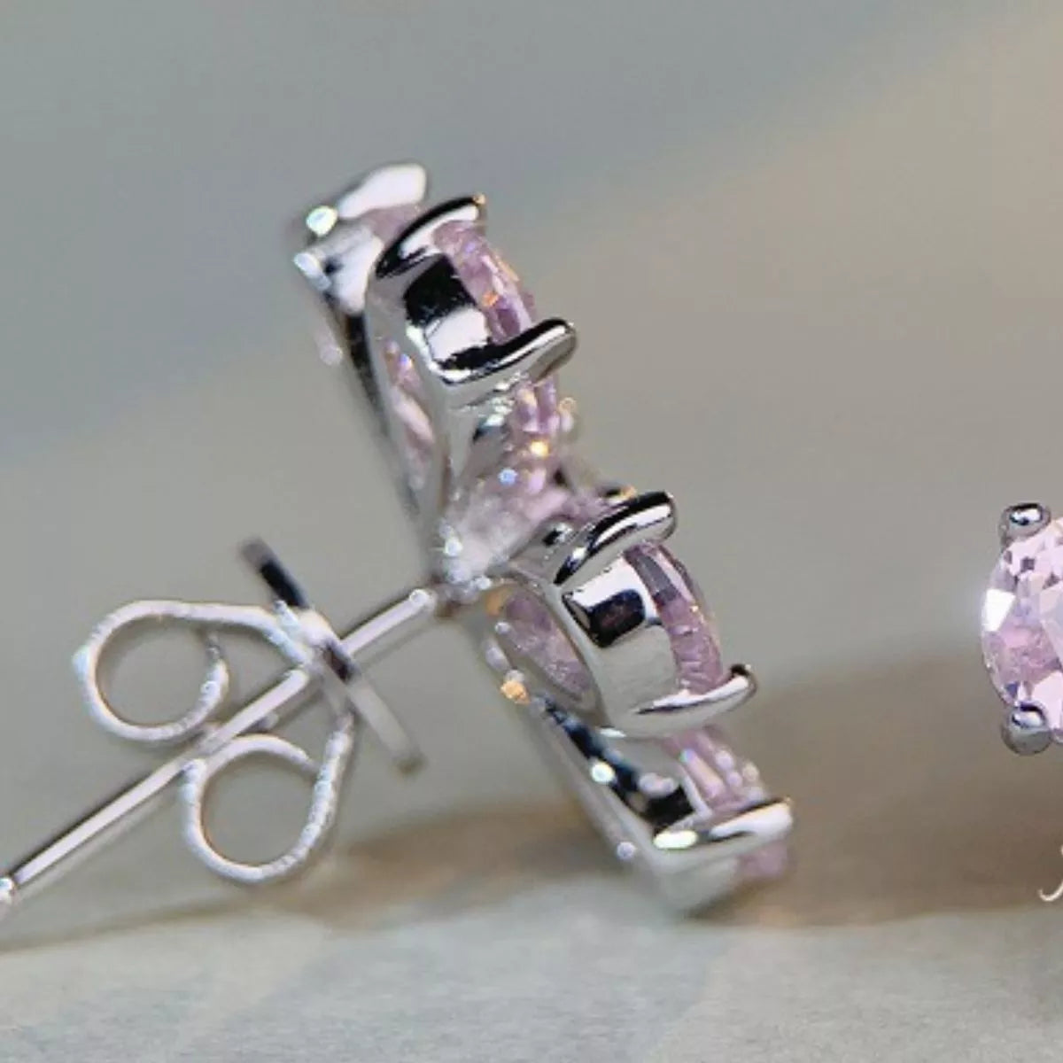 Side view of pink flower stud earring showing raised setting, post and butterfly back