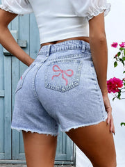 Back view of light-wash denim shorts with embroidered pocket detail