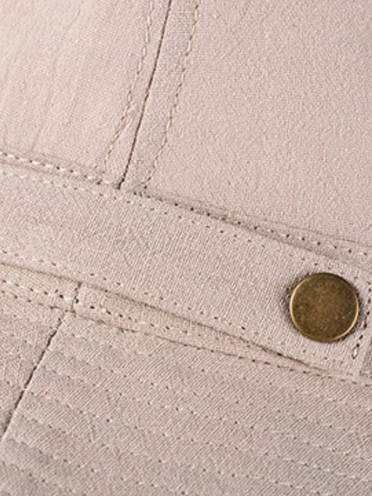 Close view of khaki hat side snap fastener and stitched band