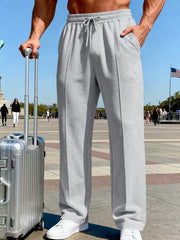 Front view of olive wide-leg drawstring pants against a blue-sky backdrop.