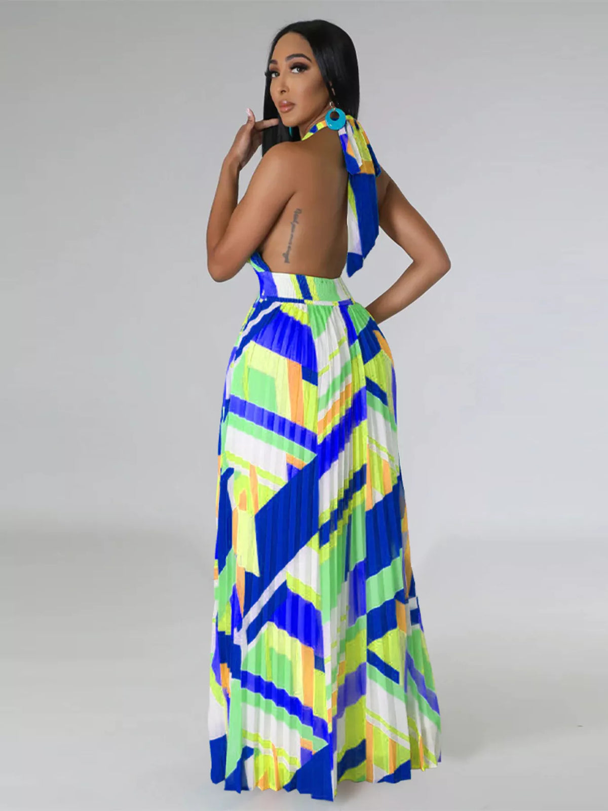 Three-quarter rear view of a blue and lime halter maxi dress showing the open back and neck ties.