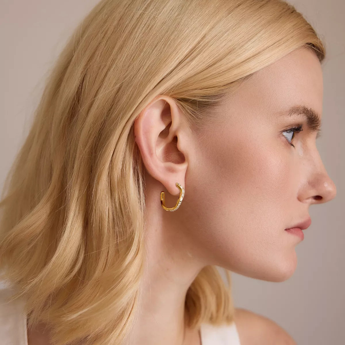 Model wearing a gold-tone zircon hoop earring