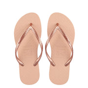 Pair of peach-coloured flip-flops with metallic rose-coloured toe-post straps, top view