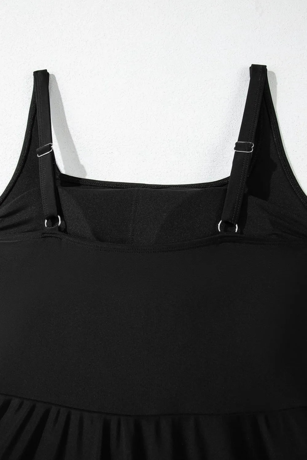 Close-up of the black swim dress square neckline and adjustable shoulder straps.