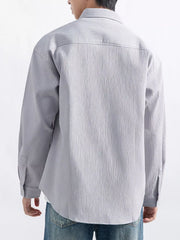 Model wearing the pale textured shirt with sleeves down