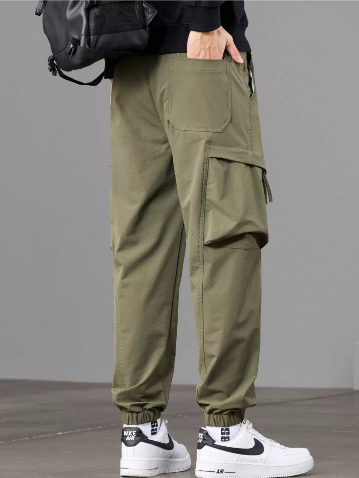 Back view of olive joggers highlighting the rear pocket and side cargo pocket.