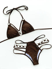 Close-up flat lay of brown bikini top and ring-detail bottoms