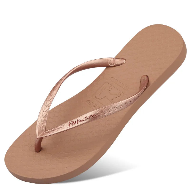 Tan flip-flop with rose-coloured toe-post straps and textured footbed