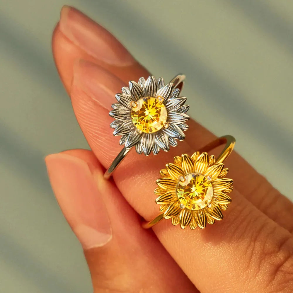 Two sunflower rings displayed across fingers