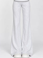 Light grey wide-leg flare pants worn with white shoes, front view