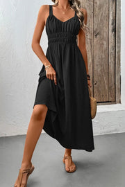 Three-quarter view of black ruched cami dress with flowing skirt