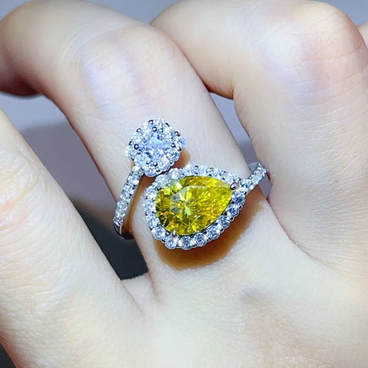 Yellow pear-shaped bypass ring worn on hand