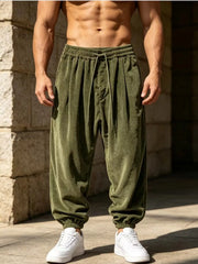 Model wearing olive green loose-fit corduroy joggers with white sneakers