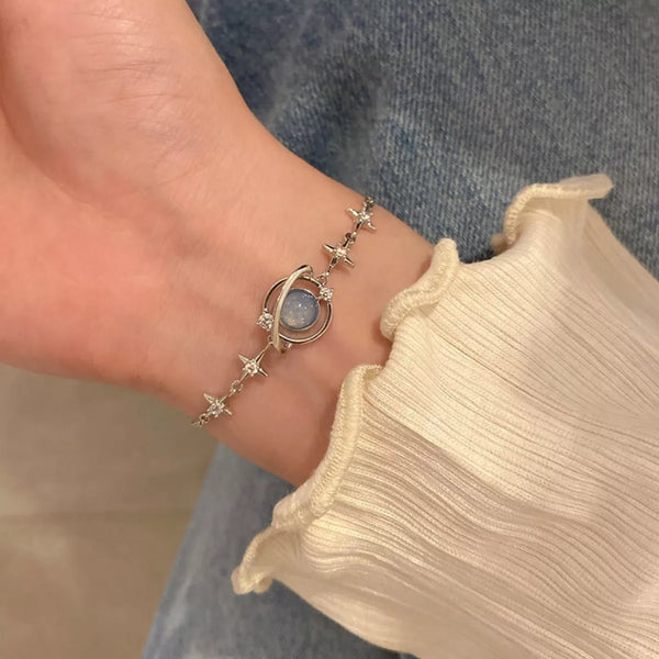 Planet bracelet with round glass centerpiece worn on the wrist