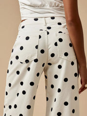 Close view of black polka dots on cream denim and back pocket