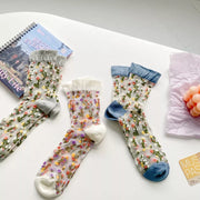 Three floral sheer crew socks in gray, cream and blue cuff colorways