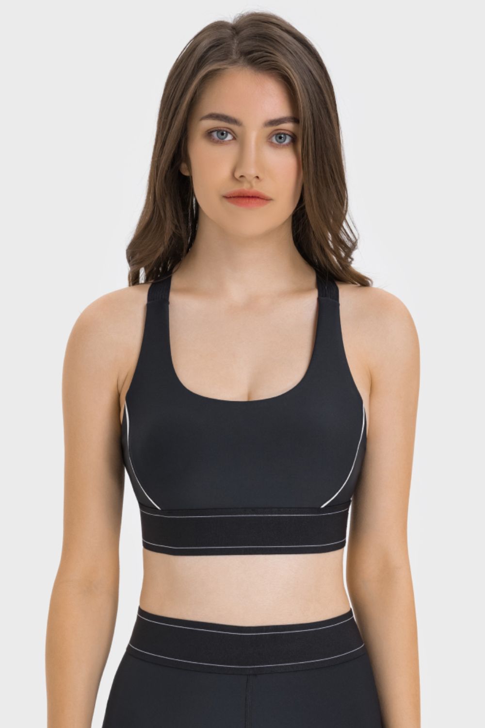 Front view of black sports bra with white piping and wide hem