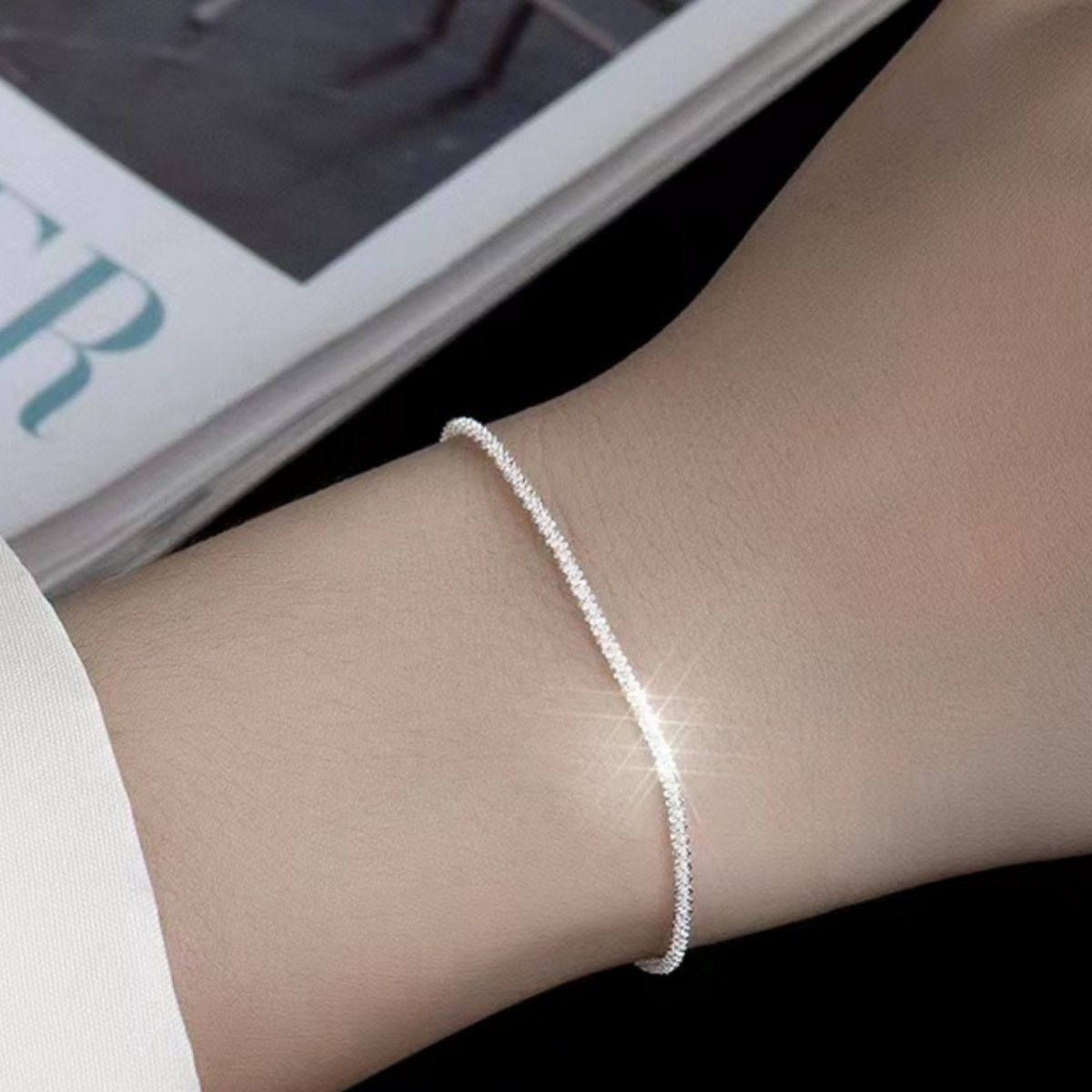 Fine silver chain bracelet shown on a wrist